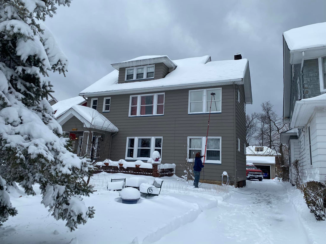 Window Cleaner using a Water Fed Pole to Clean House in Snowy Conditions