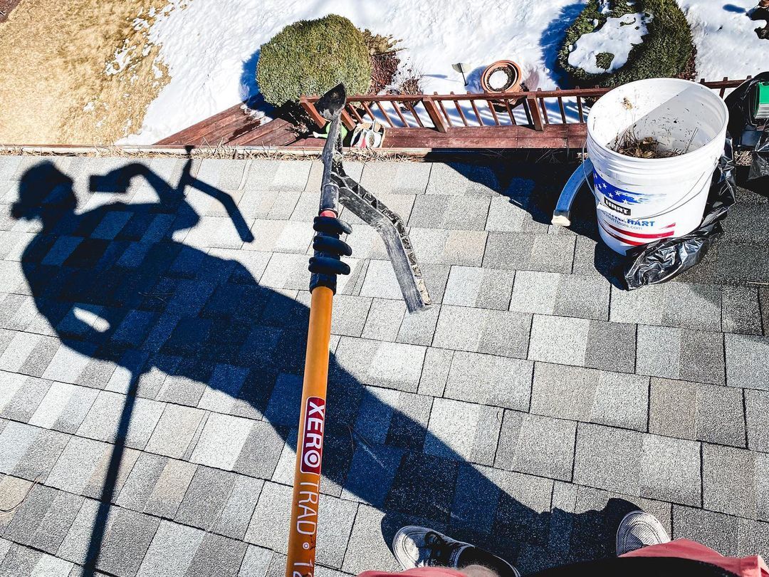 Gutters Getting Cleaned on a Snowy Day With a Trad Pole and Gutter Hawg
