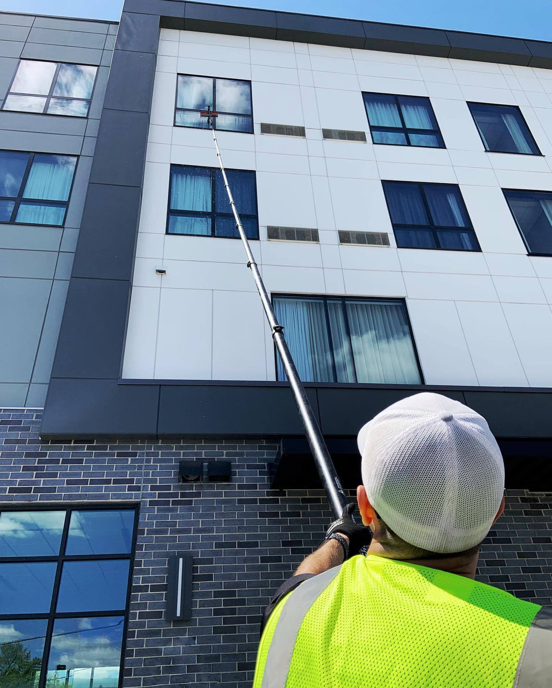 Winder Cleaner Using Water Fed Pole on Tall Building