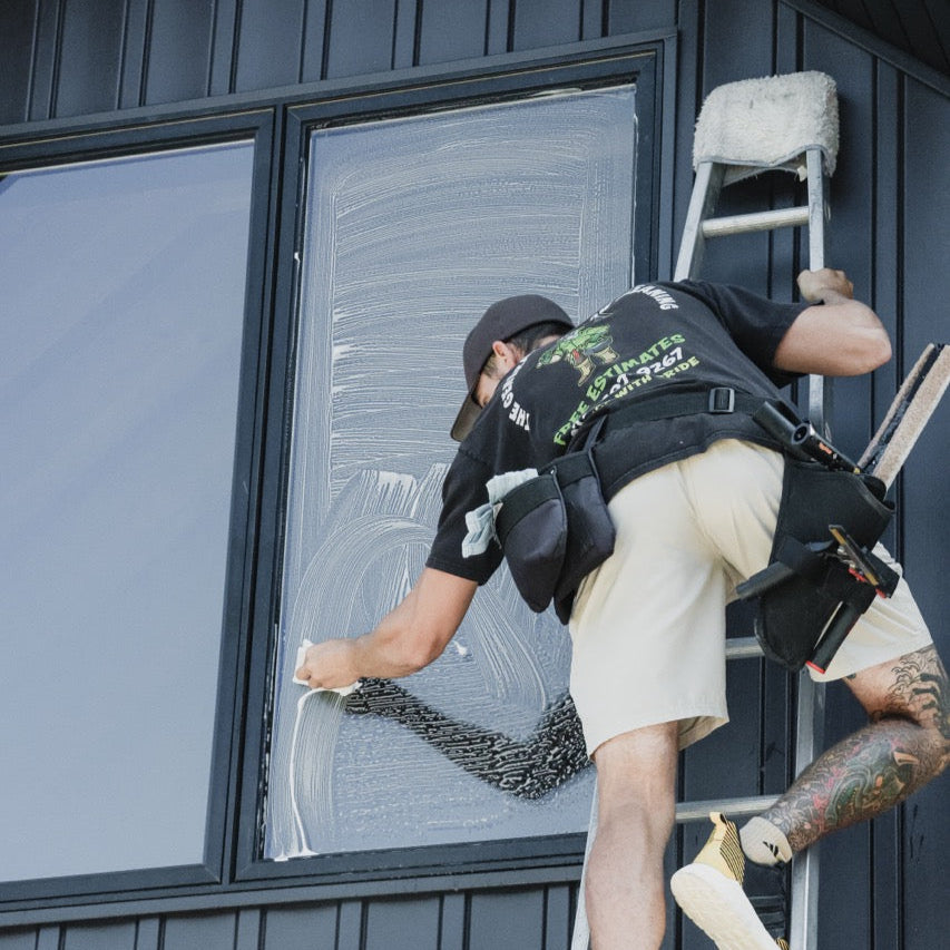 Metallic Ladder Aluminum Open Top Section in 8 Foot Being Used to Allow a Window Cleaner to Access Tall Windows for Cleaning.