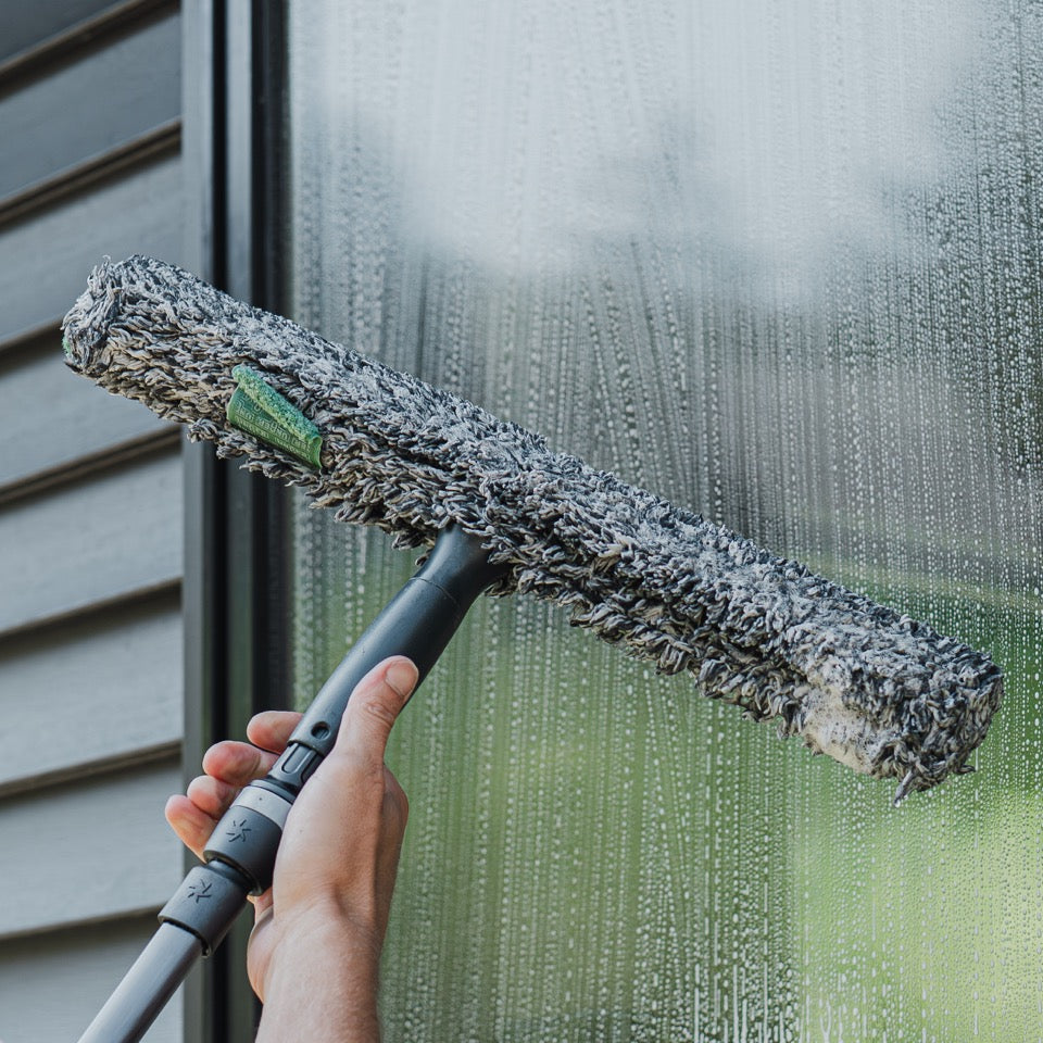 Moerman Mono Ergonomic T-Bar Being Attached to a Window Cleaning Pole with a Black Stripwasher Sleeve for Cleaning Windows.