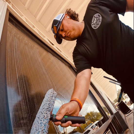 Zayne using a stripwasher to clean a window