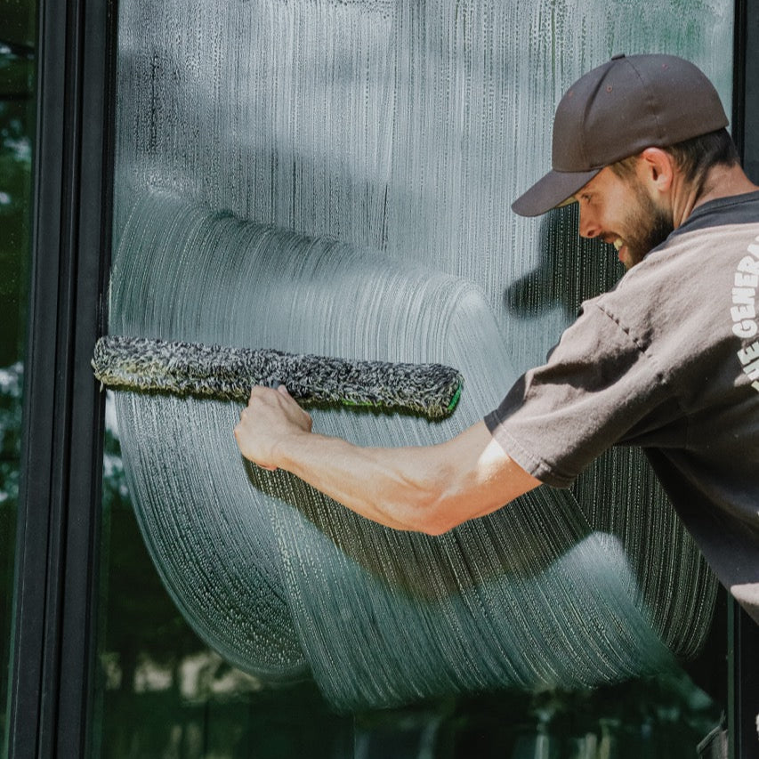 Unger Black Series Power Washer Sleeve Being Used to Scrub Down a Window for Cleaning.