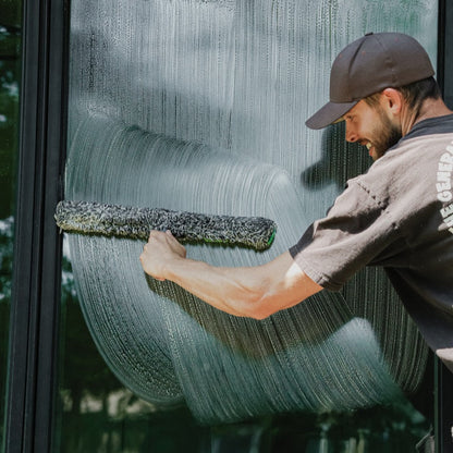 Unger Black Series Power Washer Sleeve Being Used to Scrub Down a Window for Cleaning.