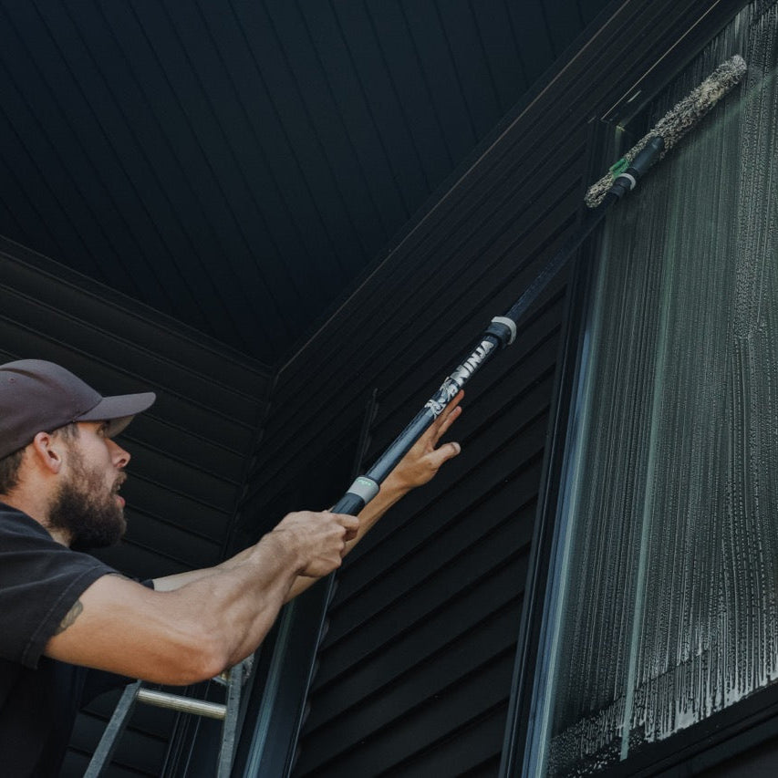 Unger Ninja Carbon Pole Extended with a Stripwasher Cleaning a Window