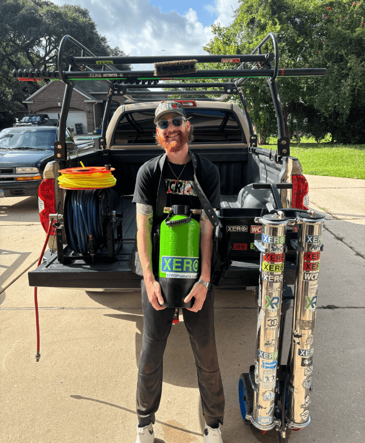 Austin leaning on truck holding a green XERO DI system